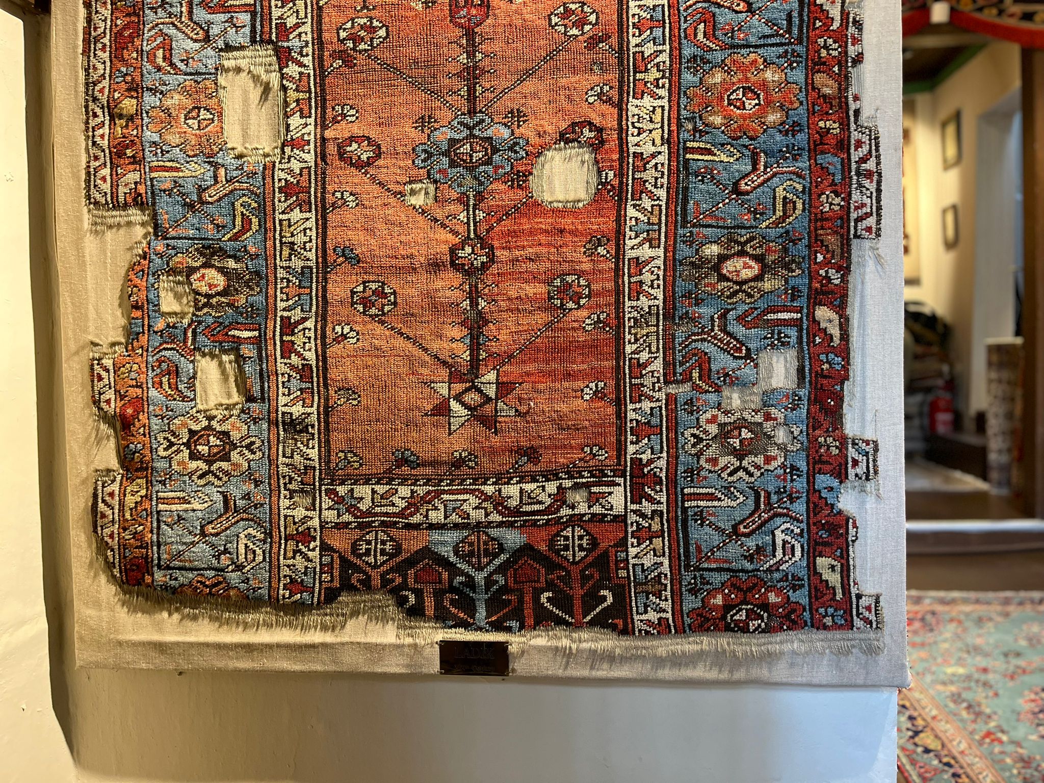 An antique rug displayed on the wall at Gordes