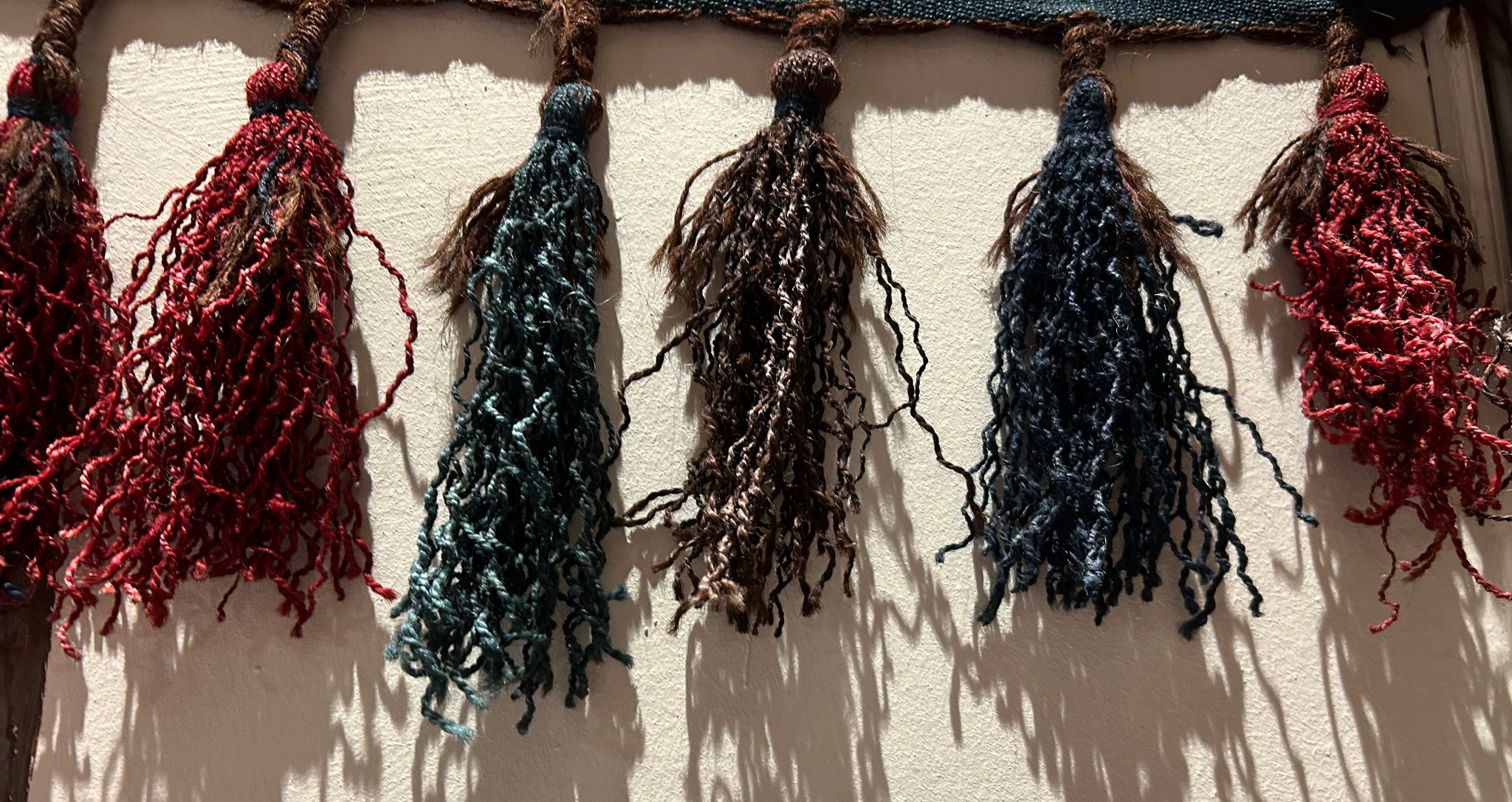 Hand-dyed wool tassels hanging in the shop
